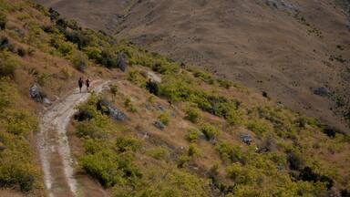 Two hikers in the distance on the way to Mt Pisa near Cromwell in New Zealand
