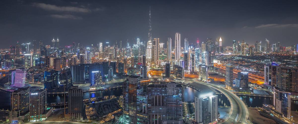 Panoramic skyline of Dubai with business bay and downtown district night timelapse.