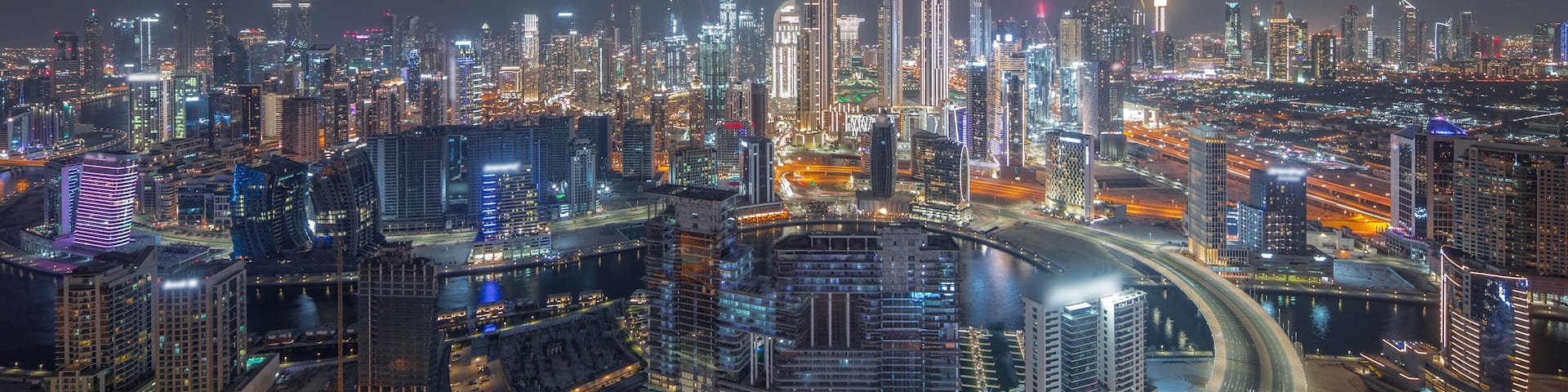 Panoramic skyline of Dubai with business bay and downtown district night timelapse.