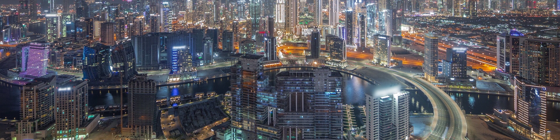 Panoramic skyline of Dubai with business bay and downtown district night timelapse.