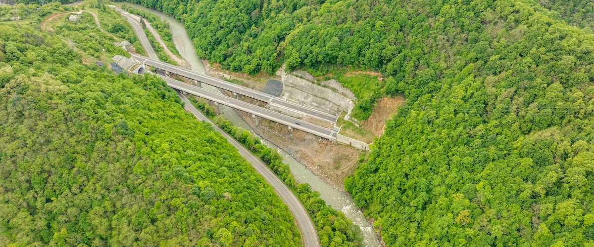 Aerial view of a quiet highway passing through a tunnels in a picturesque hilly region Rikoti Pass