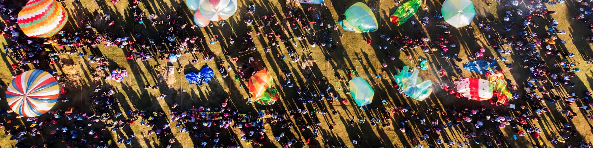 Aerial view of crowds of people and hot air balloons on ground at a festival, Ponorogo City, East Java, Indonesia