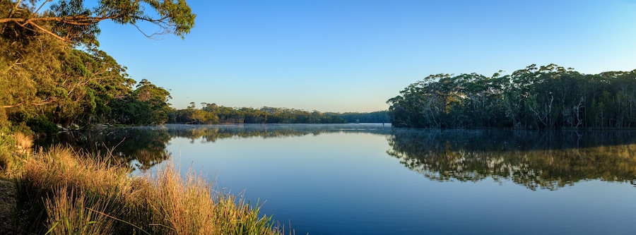A peaceful calm misty Sun rise at Lake Tabourie, New South Wales, Australia, panorama with copy space