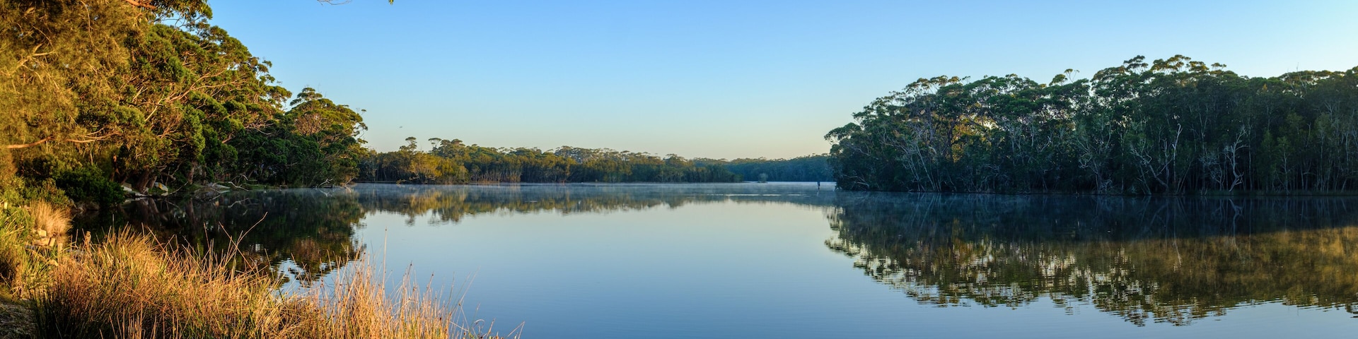 A peaceful calm misty Sun rise at Lake Tabourie, New South Wales, Australia, panorama with copy space