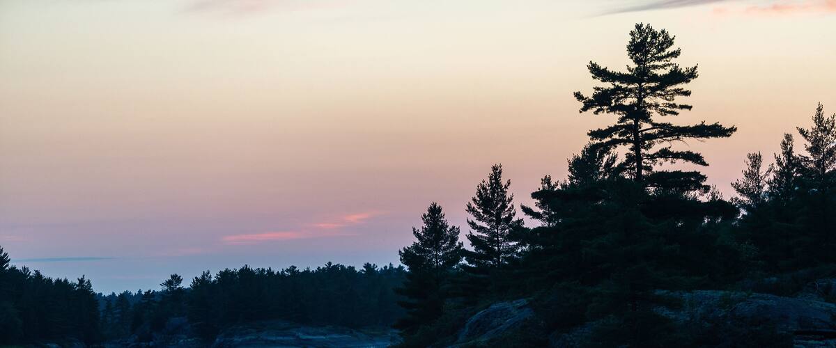 Silhouette of father and son fishing in a canoe in the Canadian wilderness