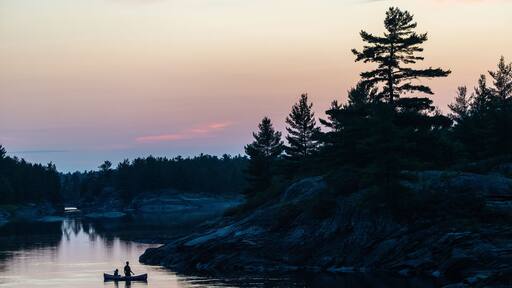 Silhouette of father and son fishing in a canoe in the Canadian wilderness