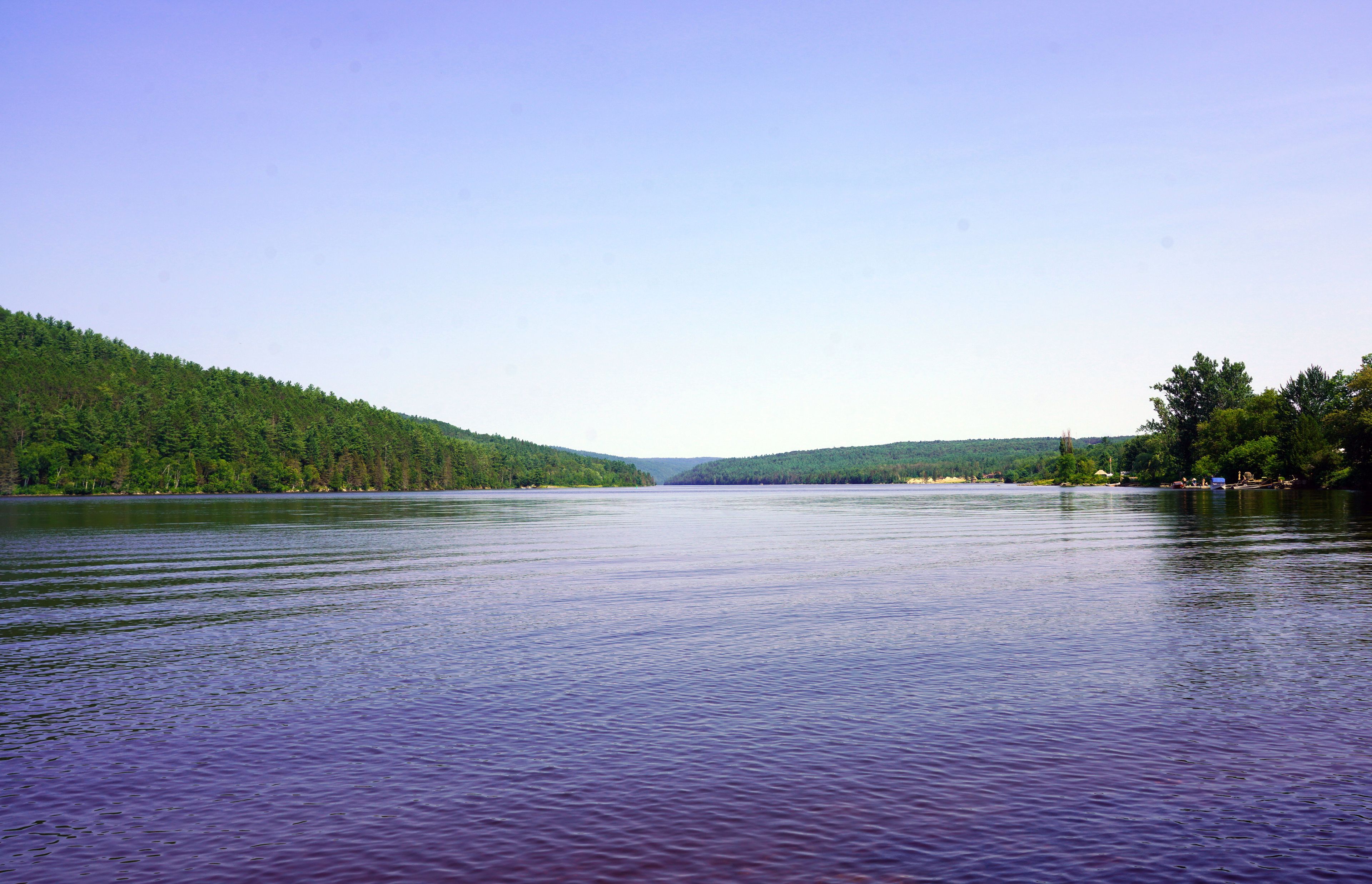 Confluence of the Ottawa and Mattawa Rivers on a summer afternoon with forested hills in the background