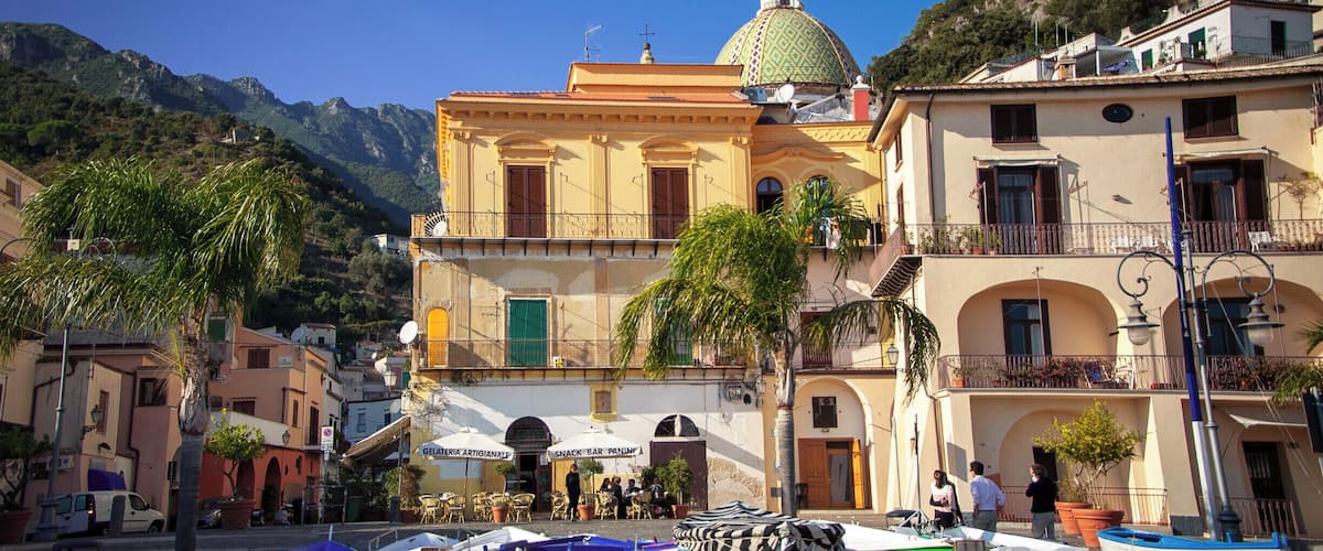 A coastal town with boats docked in front of a building with a dome.