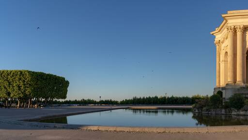 Scenic early morning panoramic view of the beautiful ancient water tower stone building and pool in historic Promenade du Peyrou garden, Montpellier, France