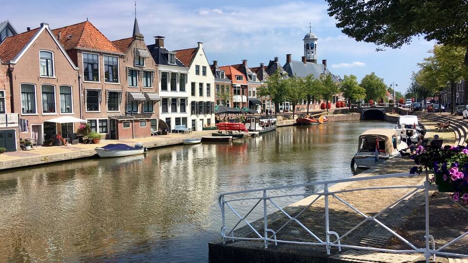 A canal with boats, a bridge, and historic buildings along the water.