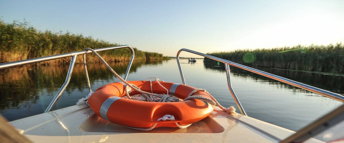 A calm river with a life preserver on a boat.