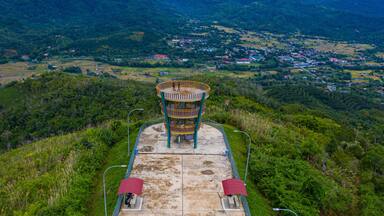 Uma torre de observação com vista panorâmica de um vale e uma cidade abaixo.