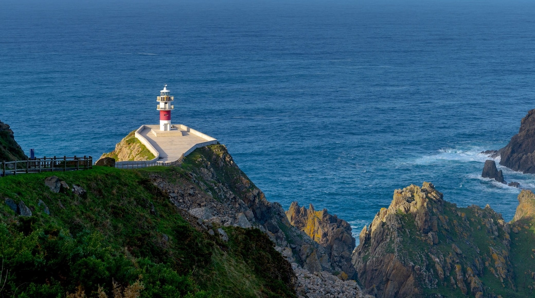 panorama of the Cabo Ortegal lighthouse in Galicia with green cliffs and sunlight and deep blue ocean