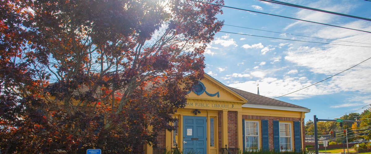 A yellow building with a blue door, labeled as the "Sampson Public Library."