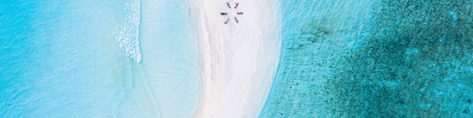 Aerial view of a group of women, doing yoga at a sandbank, Maldives.