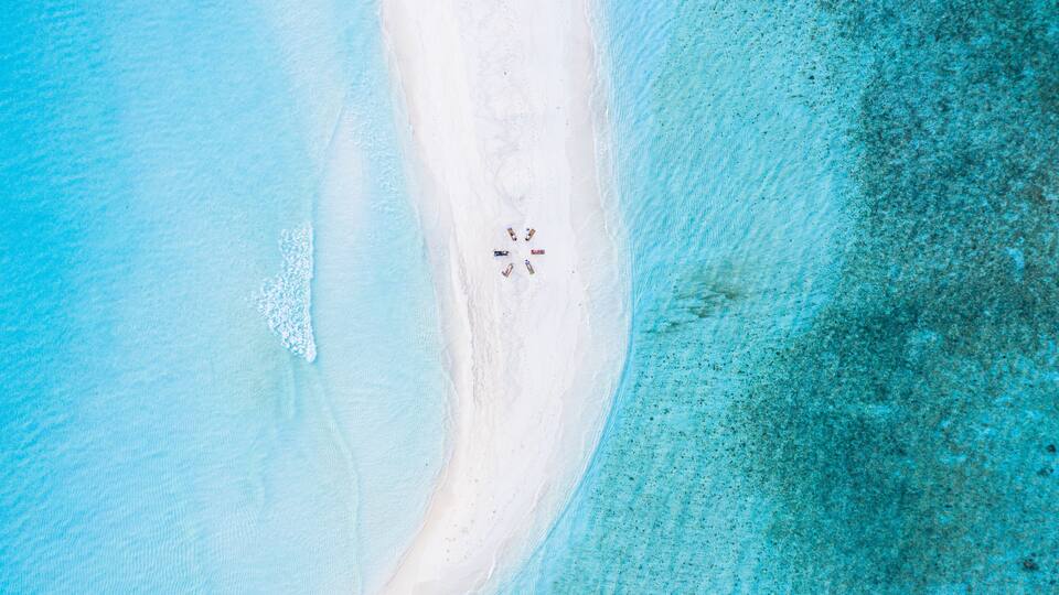 A beach with white sand and clear turquoise water.