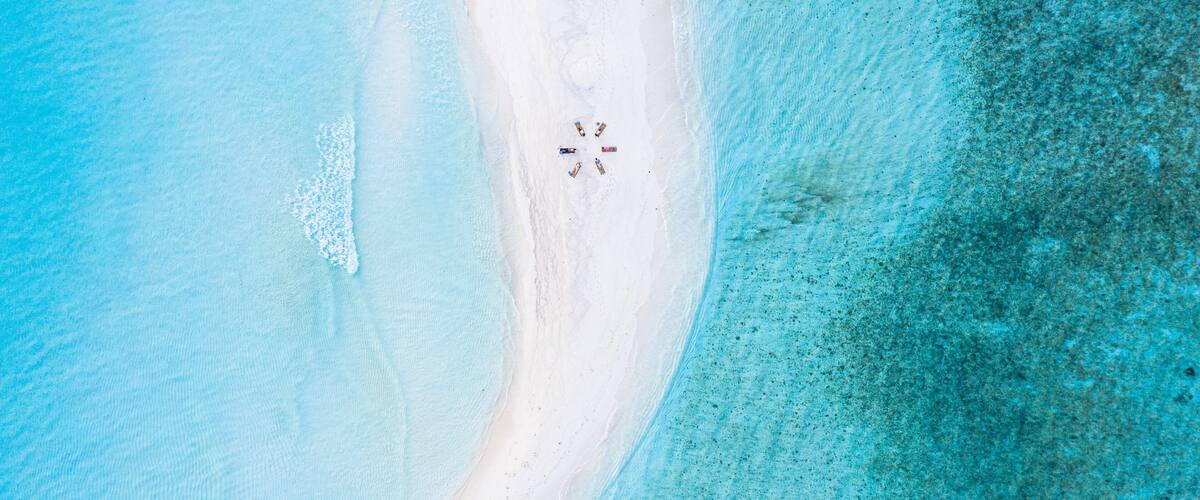 A beach with white sand and clear turquoise water.