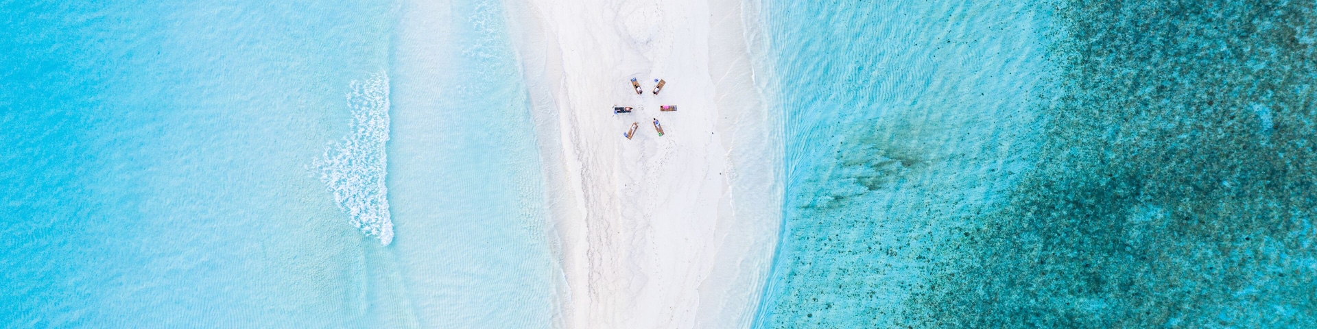 A beach with white sand and clear turquoise water.