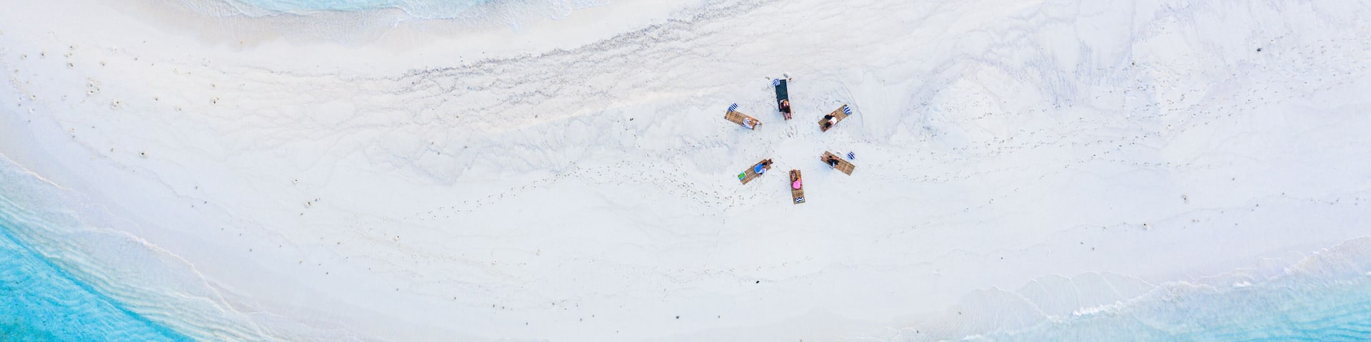 Aerial view of a group of women, doing yoga at a sandbank, Maldives.
