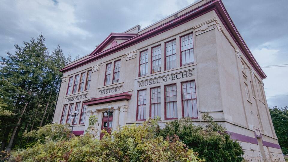 A historic building with 'Adirondack High School' and 'Museum ECHS' signs.