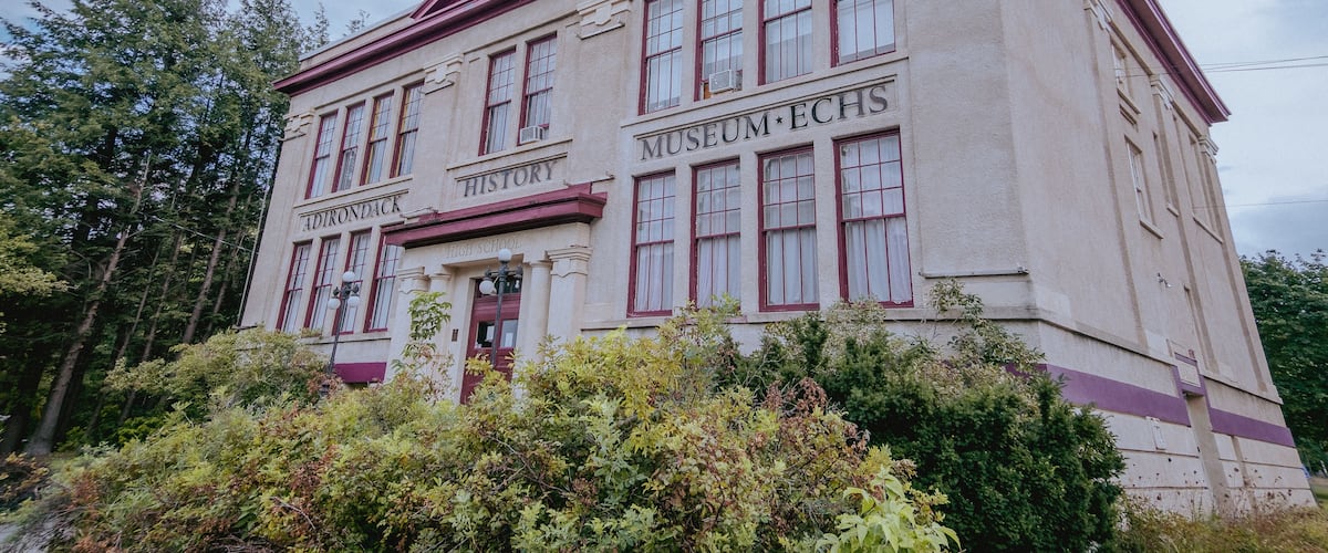A historic building with 'Adirondack High School' and 'Museum ECHS' signs.