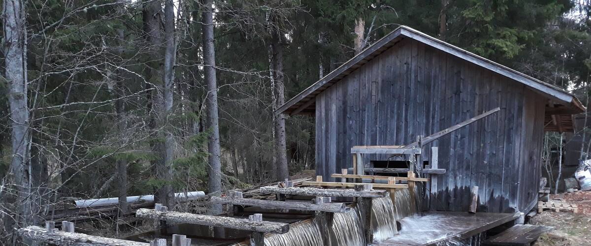 A wooden mill with a water wheel and wooden walkways.