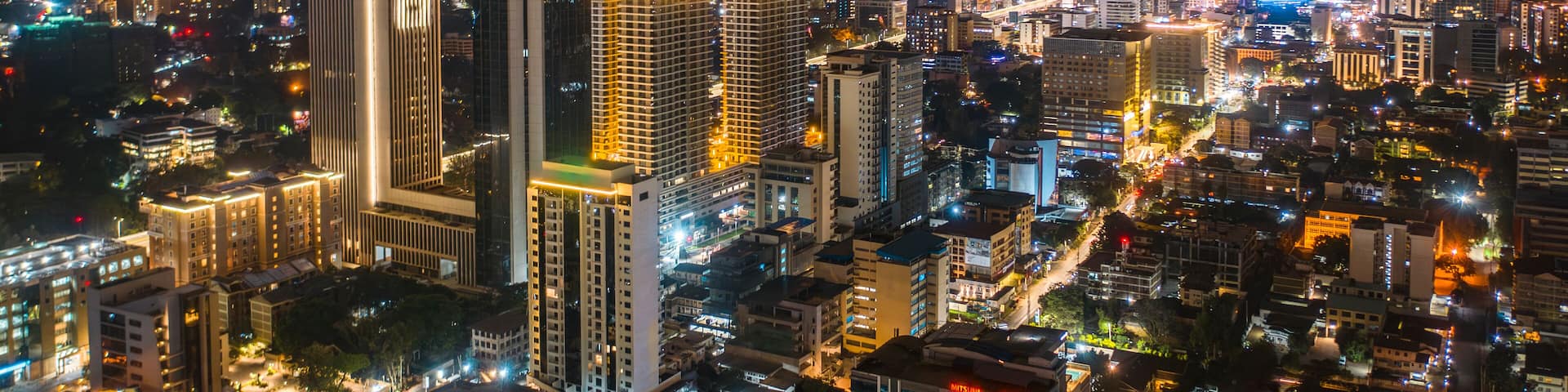 Aerial view of vibrant cityscape illuminated at night with modern skyscrapers and bustling streets, Westlands, Nairobi, Kenya.