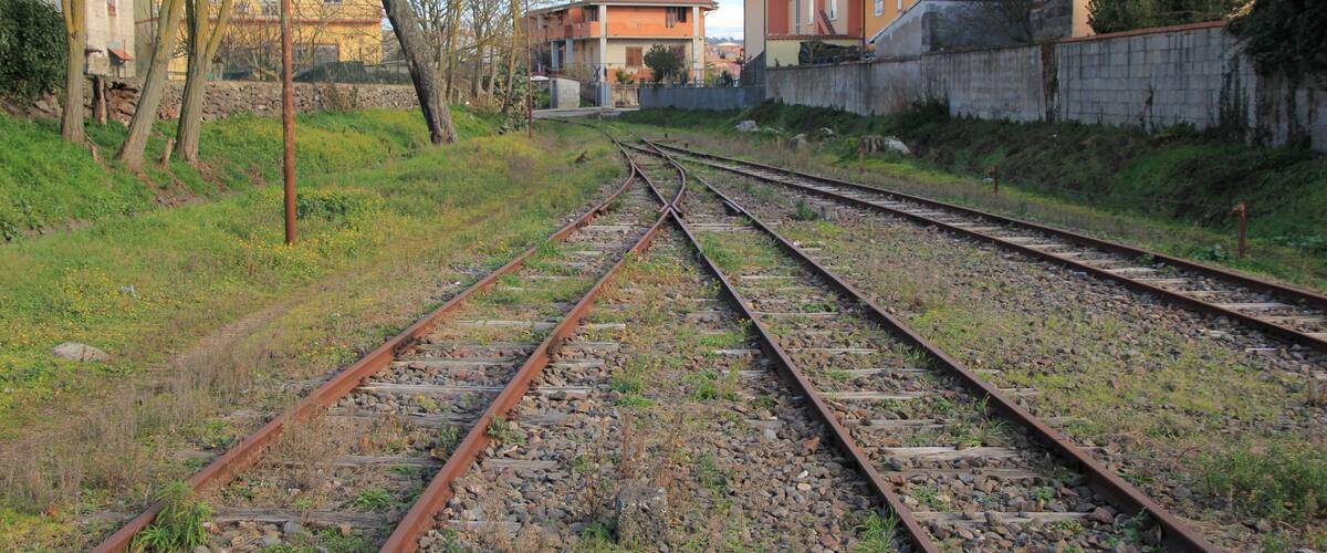 Railway tracks with houses and trees in the background.