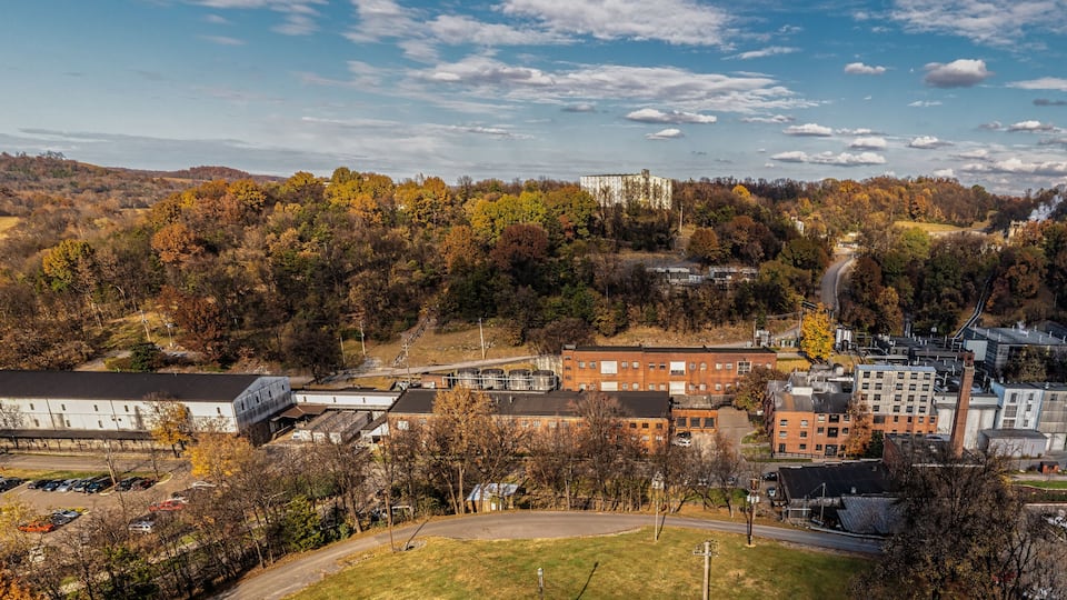 A campus with buildings, parking lots, and autumn trees.