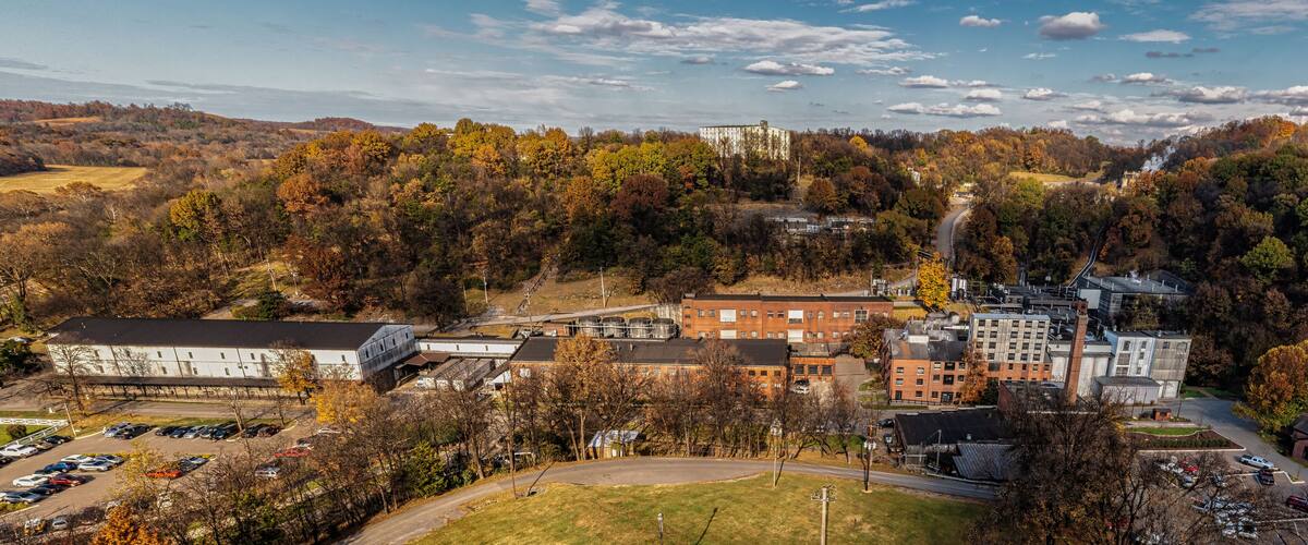 A campus with buildings, parking lots, and autumn trees.
