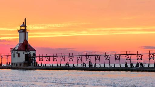 Ein Leuchtturm und eine Mole bei Sonnenuntergang.