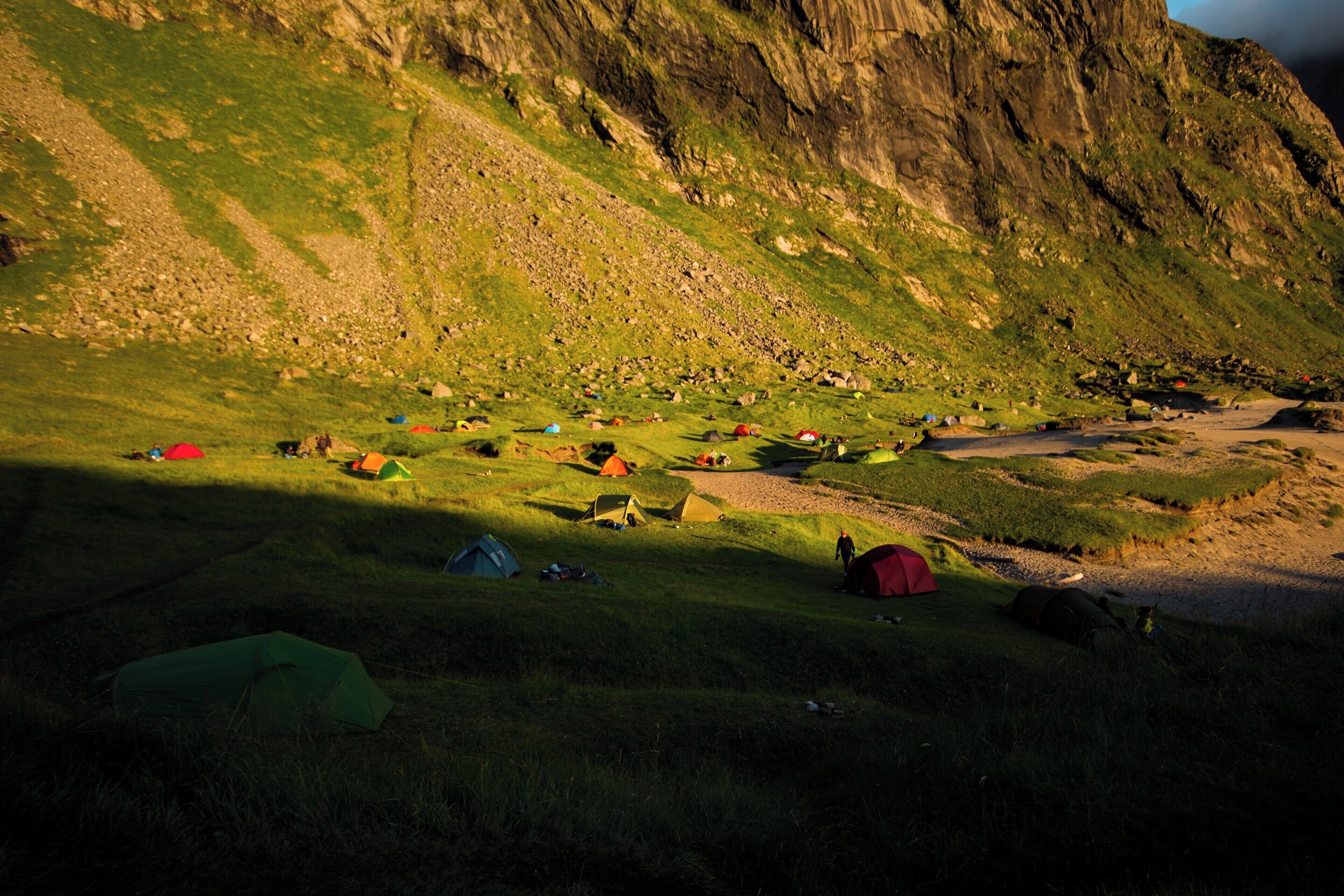 #beachtips
If a wild camping paradise exists, it would be on Kvalvika Beach on the Lofoten Islands in Norway. This place can only be reached on foot, after doing a mountain hike, and is always packed with wild campers who come there to enoy the midnight sun. I shot this photo in July 2017, around midnight, when the sun was at its lowest point and shade was covering parts of the beach.