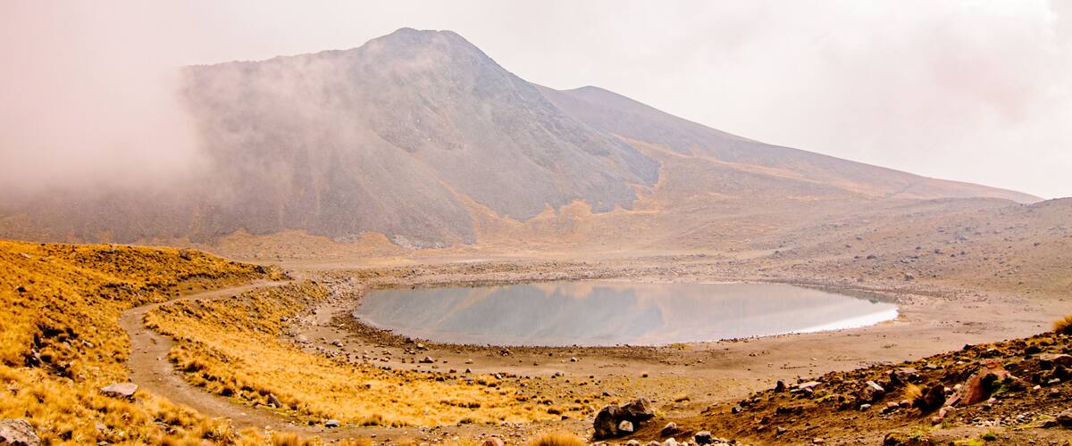 A mountain, a lake, and a dirt path.