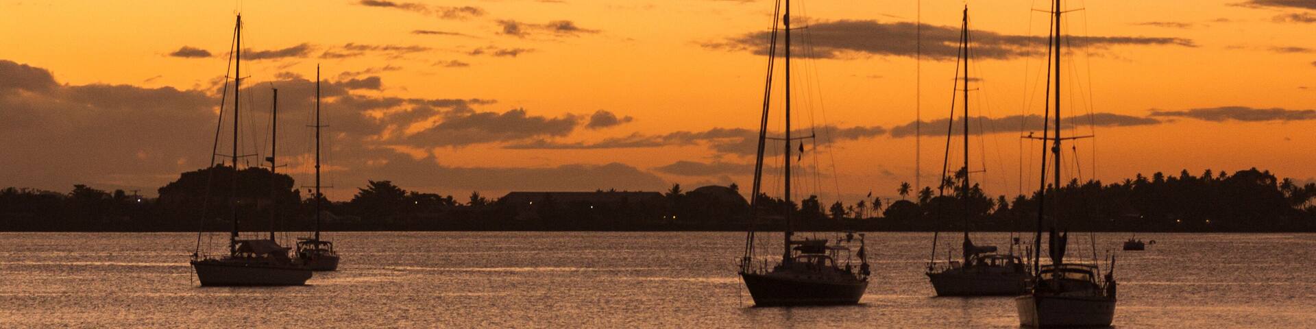 team of outriggers training at sunset in a bay in Samoa