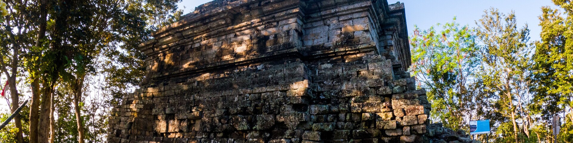 Una estructura de piedra antigua rodeada de árboles.