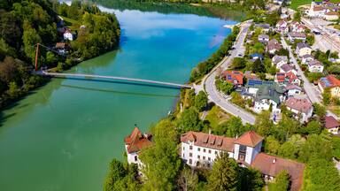A river with a bridge, a town with houses, and a forested area.