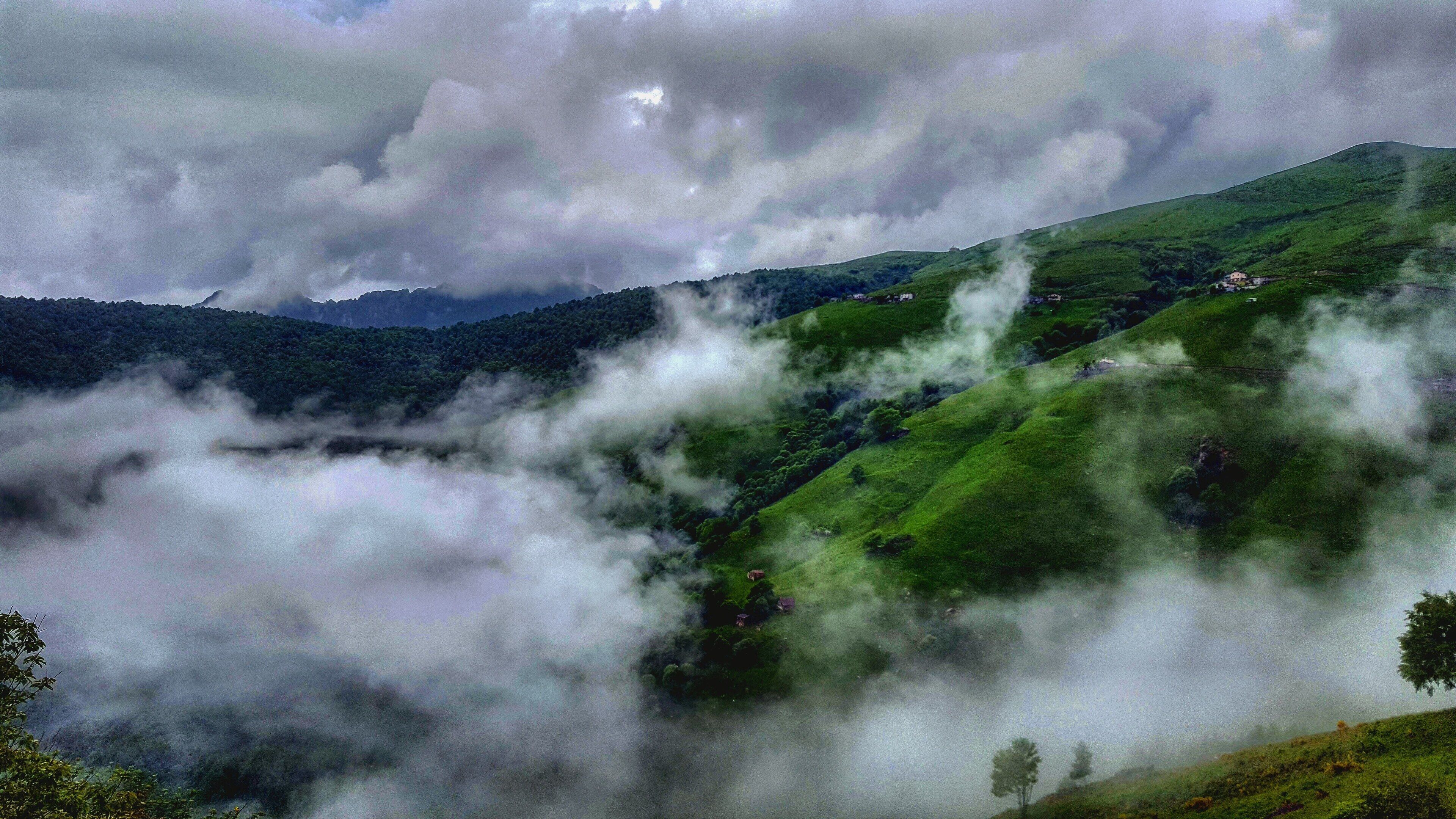 A valley with lush green hills and a river.