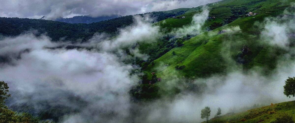 A valley with lush green hills and a river.