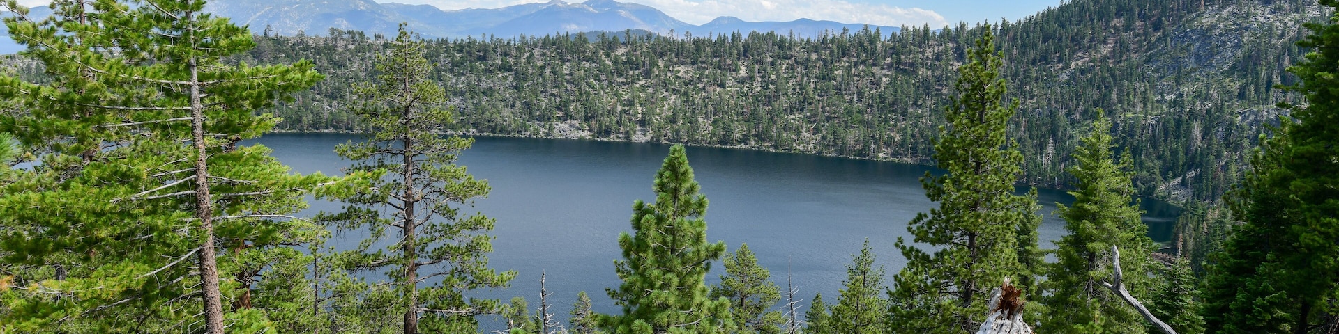 A lake surrounded by dense forests and mountains.