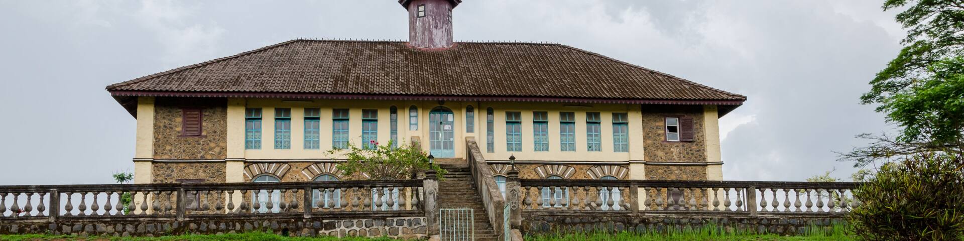 Museum at traditional palace of the Fon of Bafut with brick and tile buildings and jungle environment, Cameroon, Africa