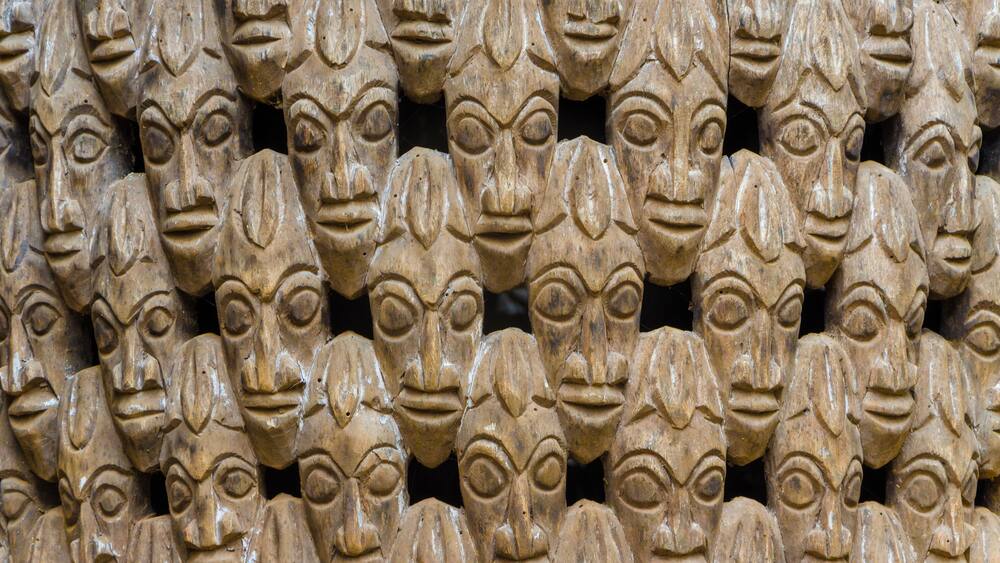 Pattern of many wood carved heads on chair at traditional Fon's palace in Bafut, Cameroon, Africa
