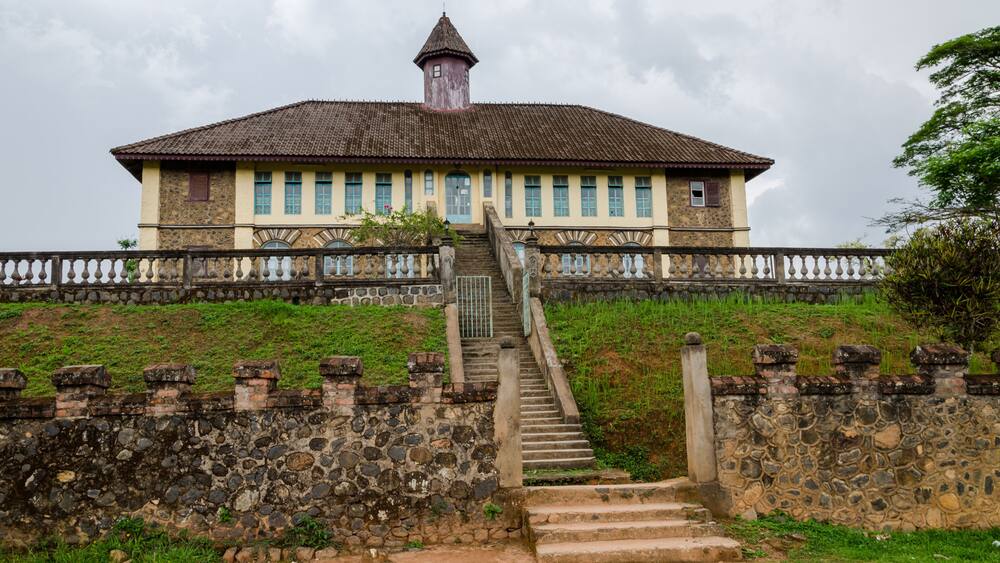 Museum at traditional palace of the Fon of Bafut with brick and tile buildings and jungle environment, Cameroon, Africa