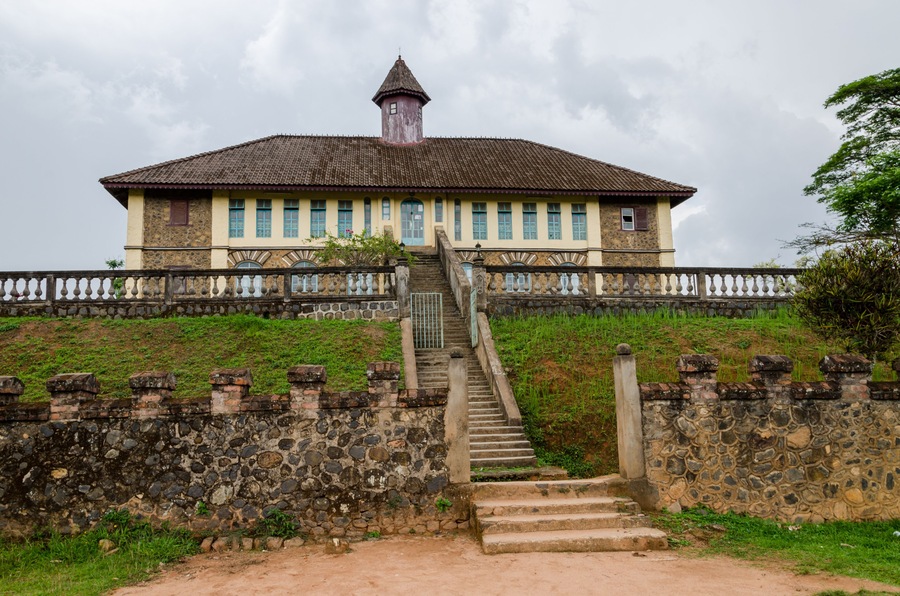 Museum at traditional palace of the Fon of Bafut with brick and tile buildings and jungle environment, Cameroon, Africa