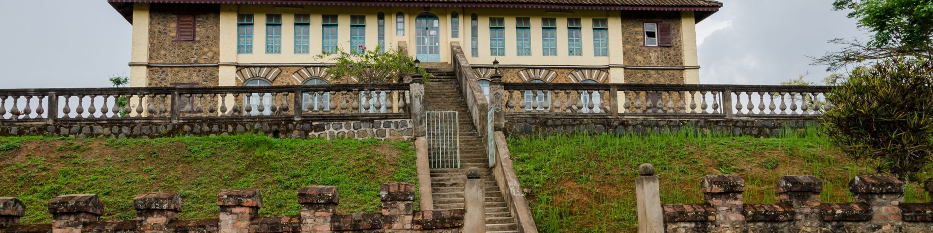 Museum at traditional palace of the Fon of Bafut with brick and tile buildings and jungle environment, Cameroon, Africa
