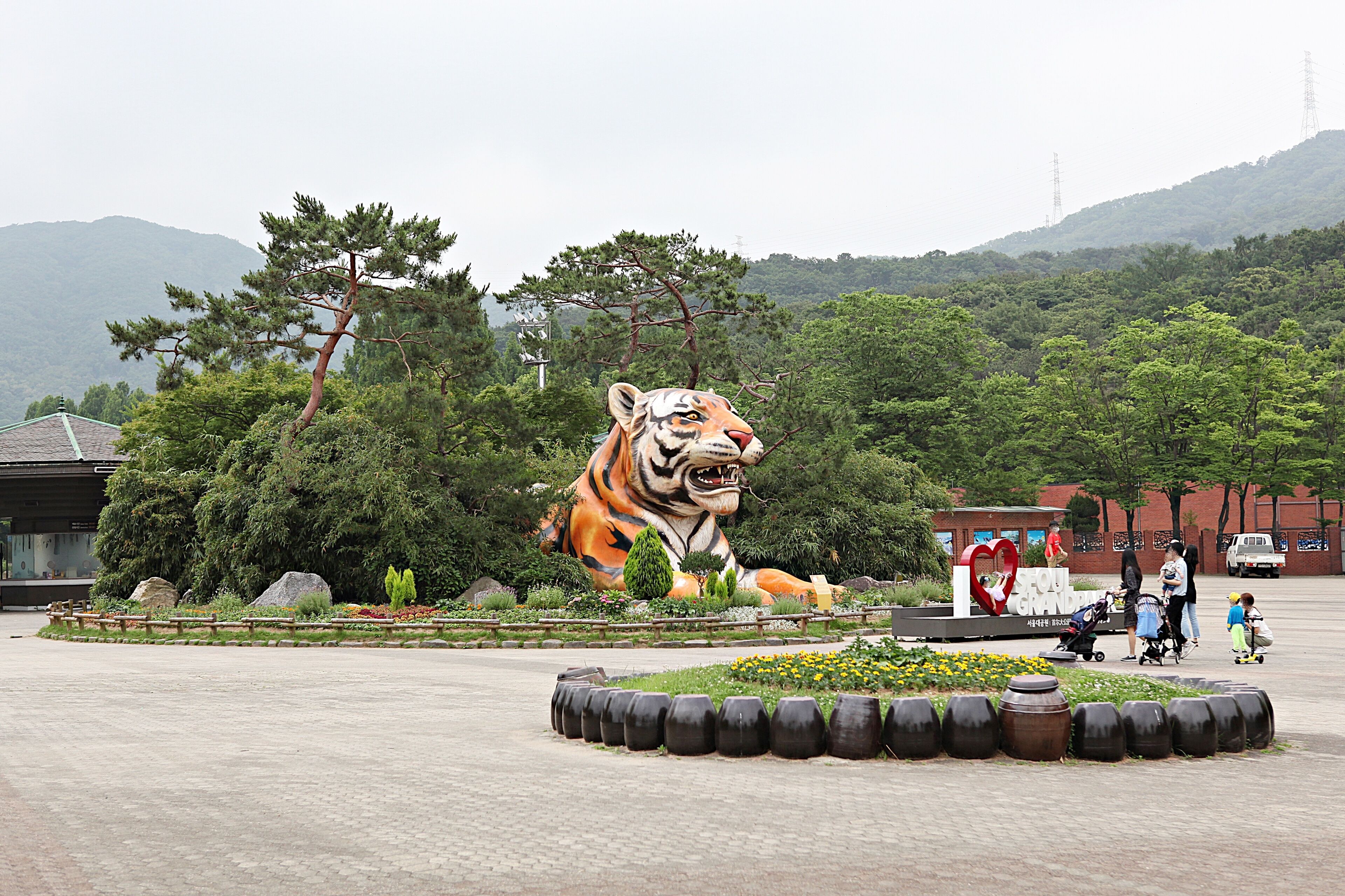A large tiger statue surrounded by greenery and trees.