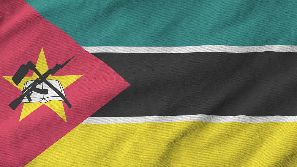 Mozambique flag depicted on folded wavy fabric of old cloth close up