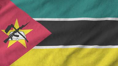 Mozambique flag depicted on folded wavy fabric of old cloth close up