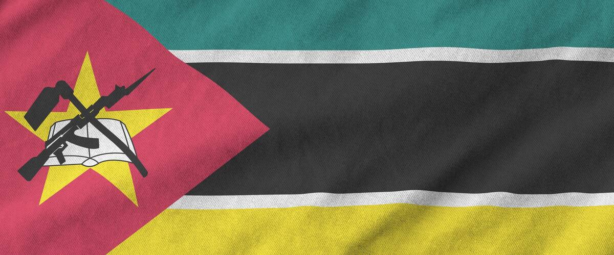 A flag with horizontal stripes of teal, black, and yellow, and a red triangle with a star and crossed rifles.