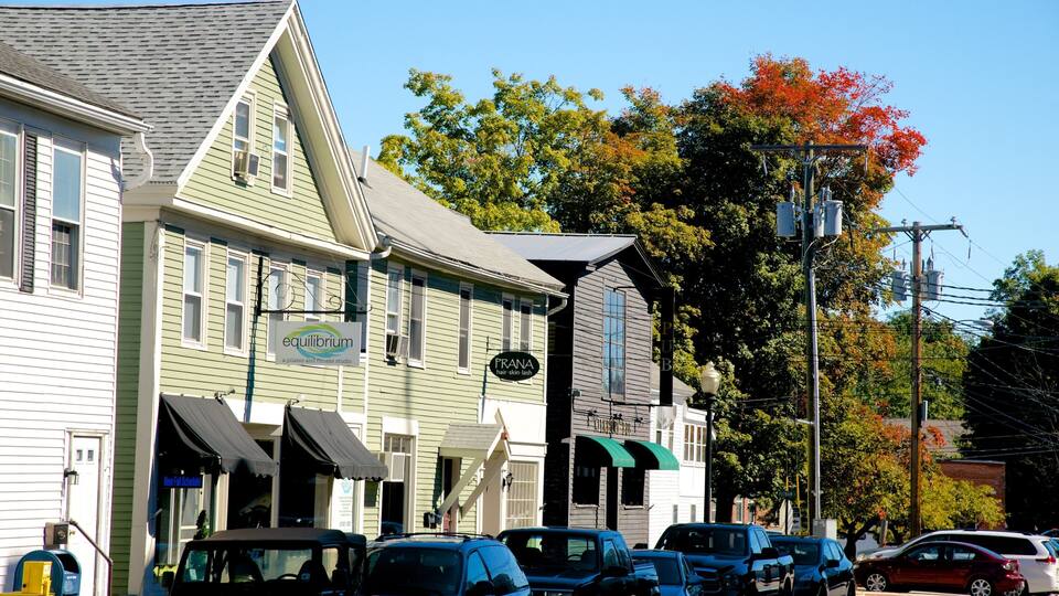 A street with buildings including a Pilates and fitness studio, a hair salon, and a pub.
