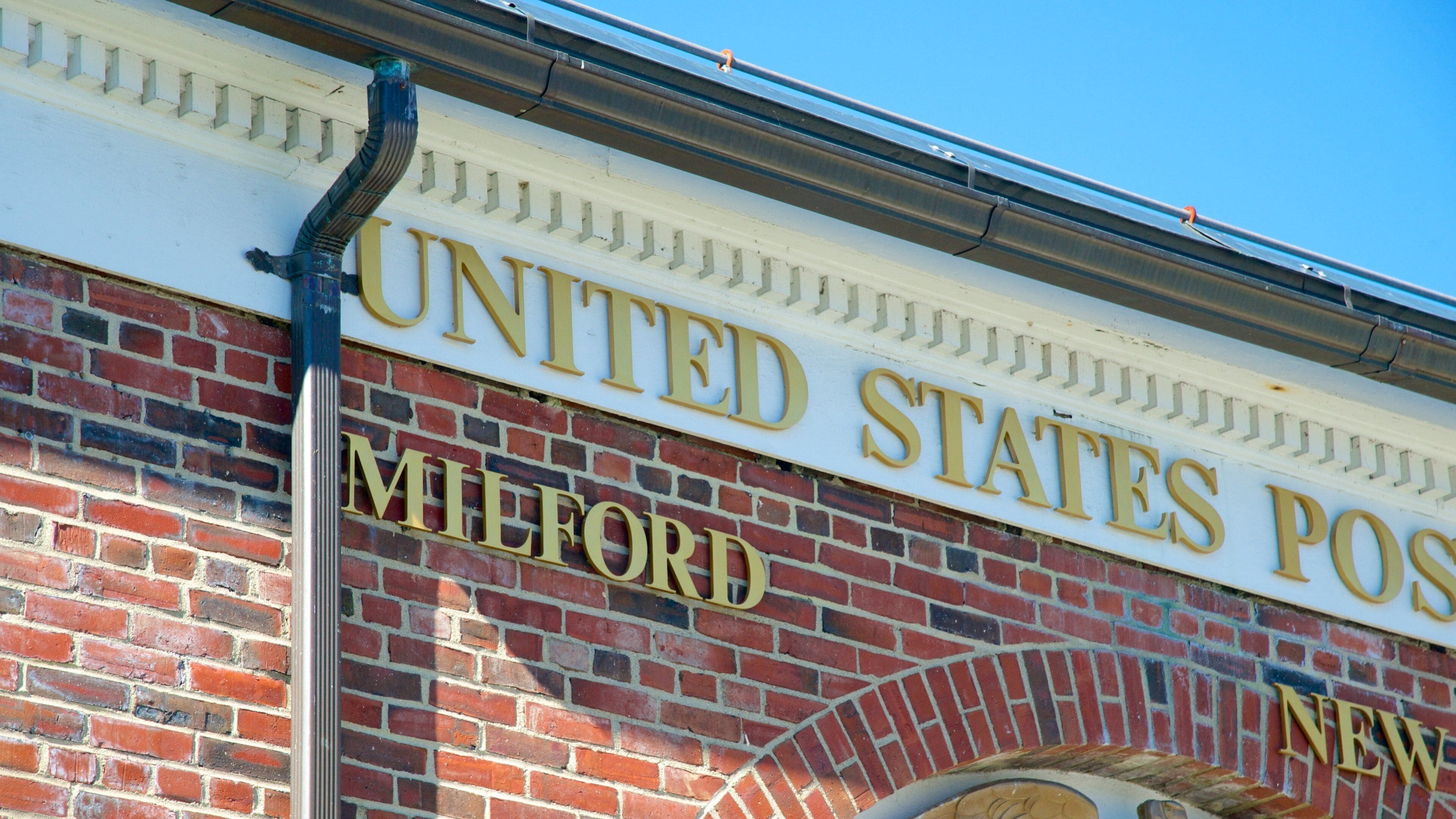 A United States Post Office sign on a brick building.